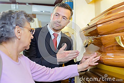 Undertaker showing woman coffin Stock Photo