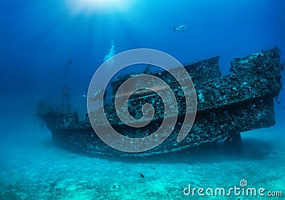 Scuba diver exploring a sunken shipwreck at the Maldives islands, Indian Ocean Stock Photo