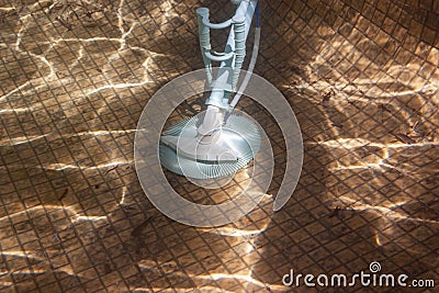 Underwater photo of an automatic pool cleaner on the pool floor Stock Photo