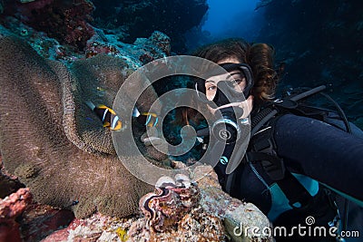 A diver poses with Anemone fish on the Reef Editorial Stock Photo