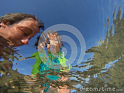 Underwater view of a father and her daughter with distorted face Stock Photo