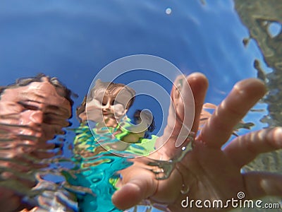 Underwater view of a father and her daughter with distorted face Stock Photo