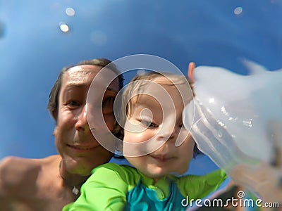 Underwater view of a father and her daughter with distorted face Stock Photo