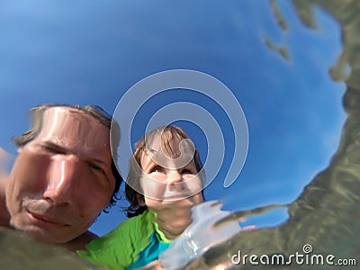 Underwater view of a father and her daughter with distorted face Stock Photo