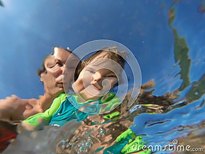 Underwater view of a father and her daughter with distorted face Stock Photo