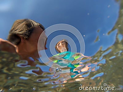 Underwater view of a father and her daughter with distorted face Stock Photo