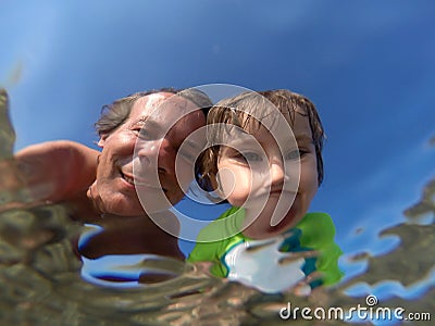 Underwater view of a father and her daughter with distorted face Stock Photo