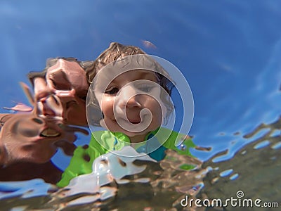 Underwater view of a father and her daughter with distorted face Stock Photo