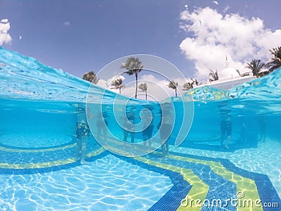 Underwater view of people having fun in hotel pool. Concept of vacation and pool party Stock Photo