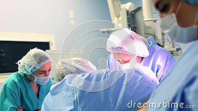 Une salle d'op?ration moderne, une ?quipe de chirurgiens fait la chirurgie Les chirurgiens et les assistants travaillent dans une banque de vidéos Une salle d'op?ration moderne, une ?quipe de chirurgiens fait la chirurgie Les chirurgiens et les assistants travaillent dans une banque de vidéos