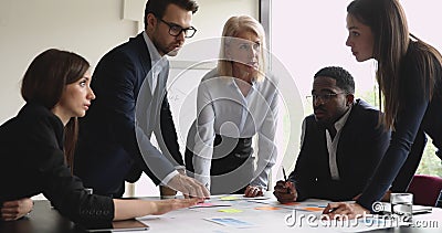 Une équipe multiraciale sérieuse avec une femme gérante brainstorming sur la paperasse banque de vidéos Une équipe multiraciale sérieuse avec une femme gérante brainstorming sur la paperasse banque de vidéos