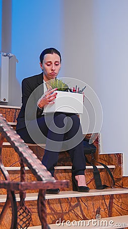 Unemployed businesswoman holding box of stuff Stock Photo