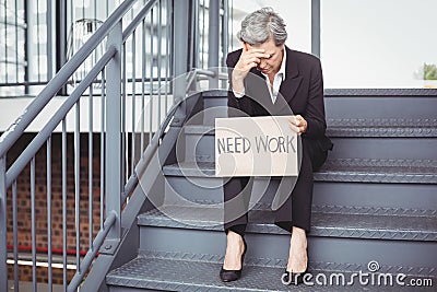 Unemployed businesswoman holding need work placard Stock Photo