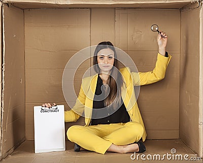 Unemployed businesswoman holds a lupe to carefully read the con Stock Photo