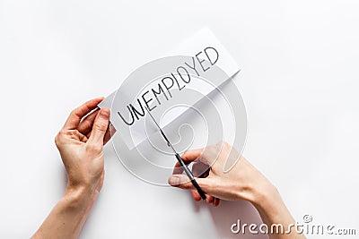 Unemployed - employed - sciccors cut paper on white desk top view. Hiring concept. Stock Photo
