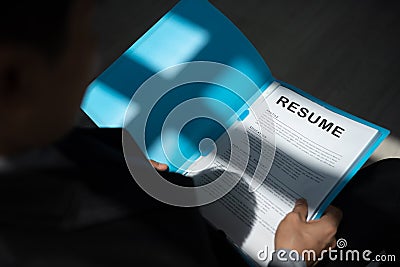 Unemployed man apply for a job sitting in queue holding resume papers waiting for job interview Stock Photo