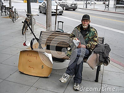 Unemployed man sitting on a bench and begging for money Editorial Stock Photo