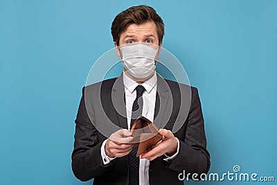 Unemployed sad man in medical mask and suit showing empty wallet Stock Photo
