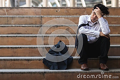 Unemployed stressed young Asian business man in suit covering face with hands. Failure and layoff concept Stock Photo