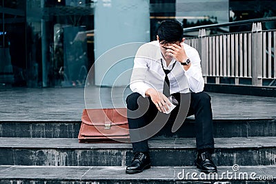 Unemployed Tired or stressed businessman sitting on the walkway Stock Photo