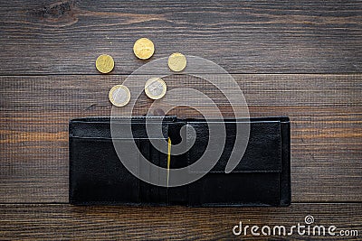 Unemployment concept. Lack of money. Coins fall out of wallet on dark wooden background top view Stock Photo