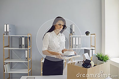 Unemployment Dismissed businesswoman upset with a cardboard box leaves the workplace from the office of the company. Stock Photo