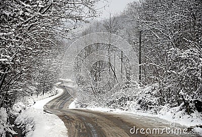 Uneven curved road through snowy forest Stock Photo