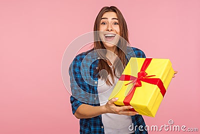 Unexpected present, holiday bonus! Portrait of surprised joyful pretty girl in checkered shirt holding wrapped box Stock Photo