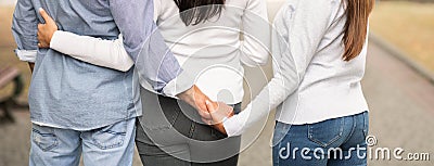 Unfaithful Boyfriend Holding Hands With Girlfriend`s Female Friend Outside, Cropped Stock Photo