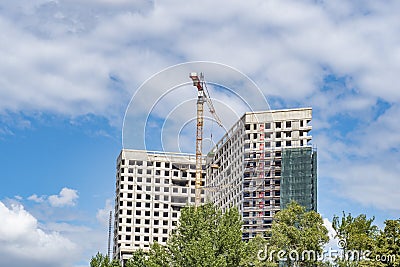 An unfinished apartment building with a tower crane. Stock Photo