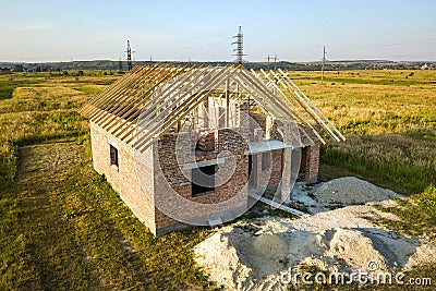 Unfinished brick house with wooden roof structure under construction Stock Photo