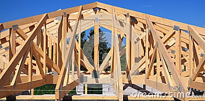Unfinished roofing wooden frame house construction with roof beams, trusses, timber, braces and eaves of a brick house building Stock Photo