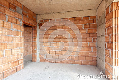 Unfinished room interior of building under construction. Brick red walls. New home Stock Photo