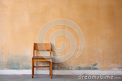 unfinished wooden chair against wall Stock Photo