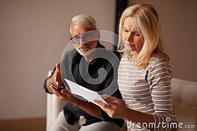 Unforeseen expenses. A mature married couple learns about bankruptcy, the minimum cash payment. Frustrated by the expensive Stock Photo