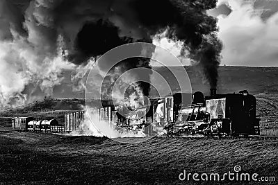 A vintage South African narrow-gauge steam locomotives steaming uphill on a cold winters morning. Stock Photo