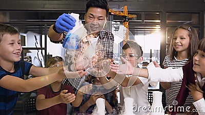 Unga asiatiska forskare som utför experiment med torr is för barn i klass Under försöksläraranläggningen lager videofilmer Unga asiatiska forskare som utför experiment med torr is för barn i klass Under försöksläraranläggningen lager videofilmer