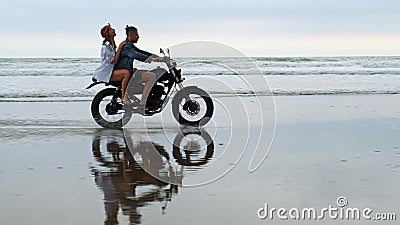 Unga h?rliga parhipsters som rider den retro motorcykeln p? stranden, den utomhus- st?enden och att rida grabben och flickan, lop lager videofilmer Unga h?rliga parhipsters som rider den retro motorcykeln p? stranden, den utomhus- st?enden och att rida grabben och flickan, lop lager videofilmer