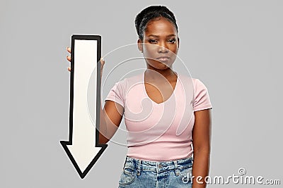 Unhappy african woman with downwards arrow Stock Photo