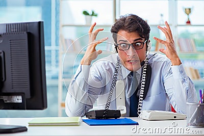 The unhappy angry call center worker frustrated with workload Stock Photo