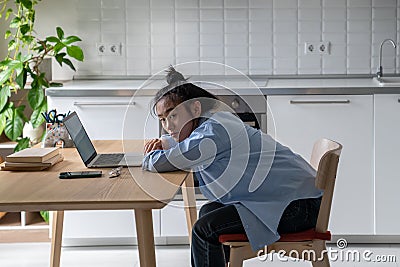 Unhappy Asian student girl sitting in front of laptop at table, feeling unmotivated to study online Stock Photo