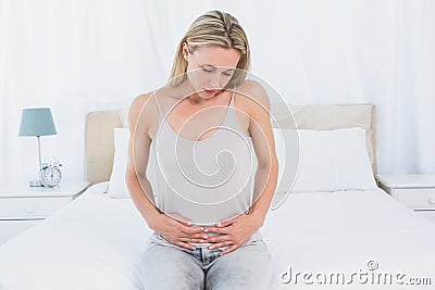 Unhappy blonde suffering from stomach pain Stock Photo