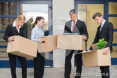 Unhappy Businesspeople With Cardboard Boxes Outside The Office Stock Photo