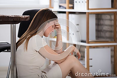 Unhappy Businesswoman Sitting In Office Stock Photo