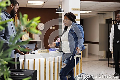 Unhappy couple at hotel front desk Stock Photo