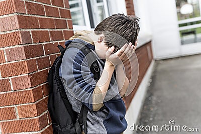 Unhappy Pre teen boy at school Stock Photo