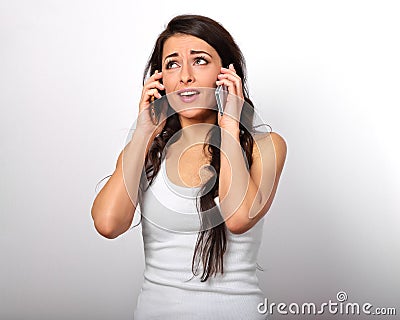 Unhappy doubt thinking stressed woman holding two mobile phones Stock Photo