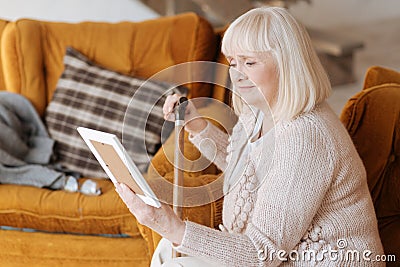 Unhappy elderly woman holding a photograph Stock Photo