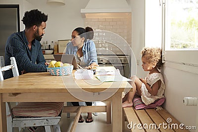 Unhappy Girl Watching Parents Arguing In Kitchen Stock Photo