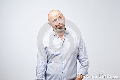 Unhappy gloomy bearded attractive male is looking puzzled as he does not understand what is going on, feels depressed Stock Photo